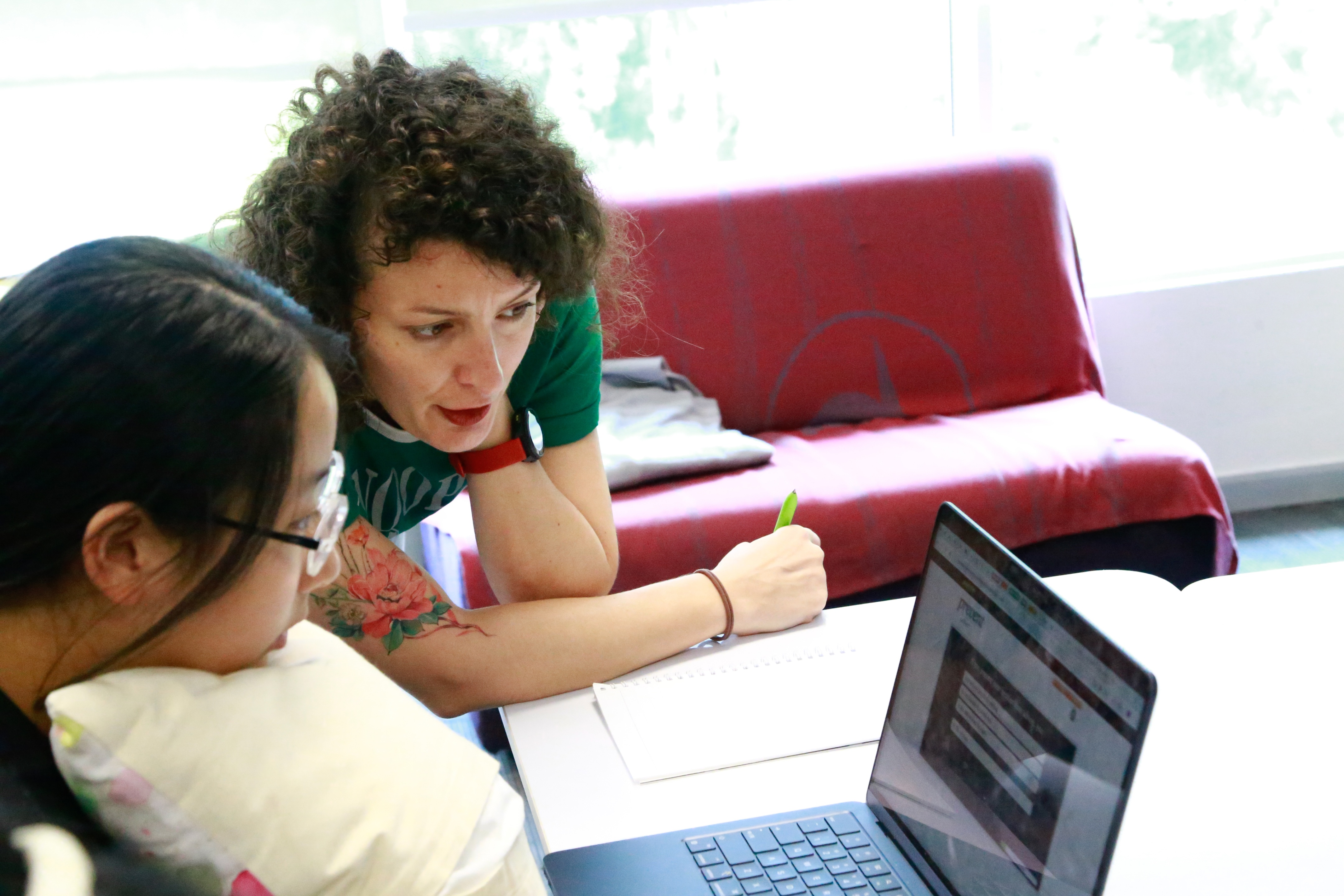 Teacher helping student with laptop